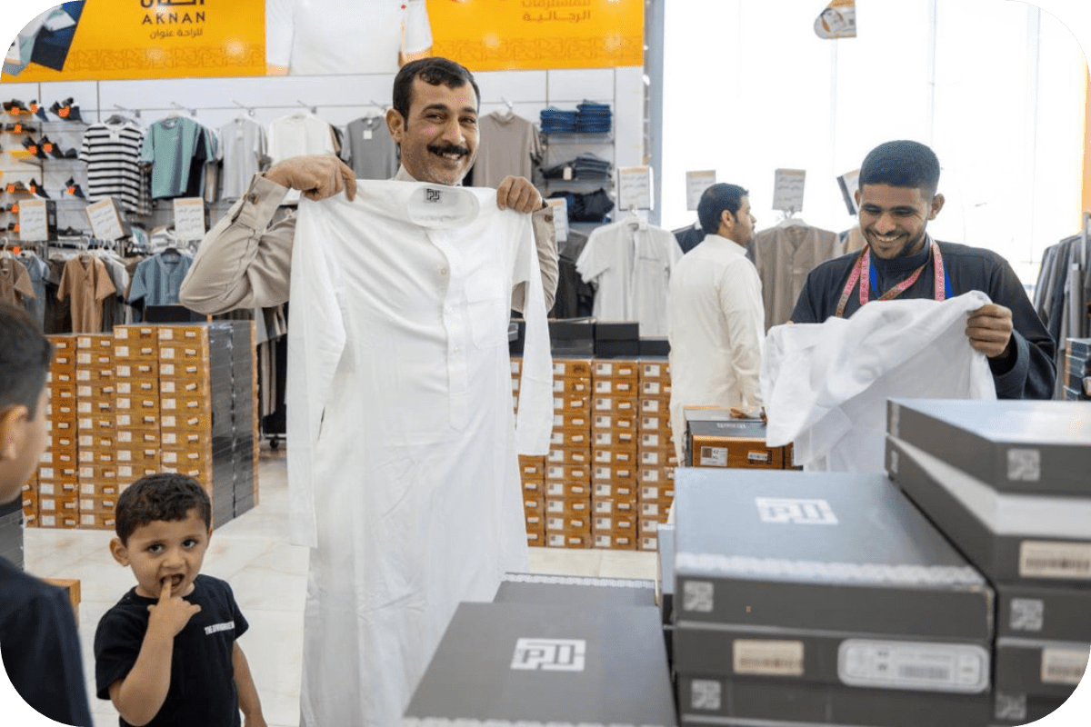 a person holding a thobe in a shop