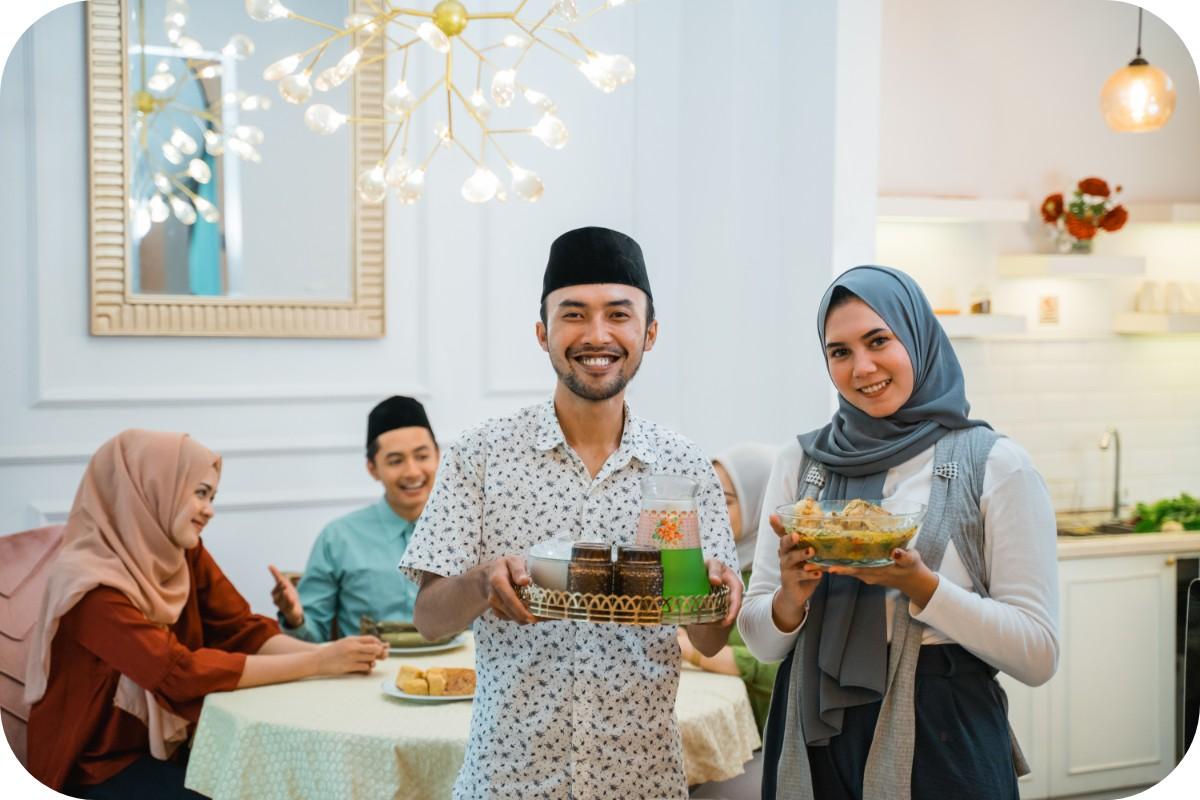 A joyful couple smiles while holding plates of delicious food, showcasing their shared meal and happiness together