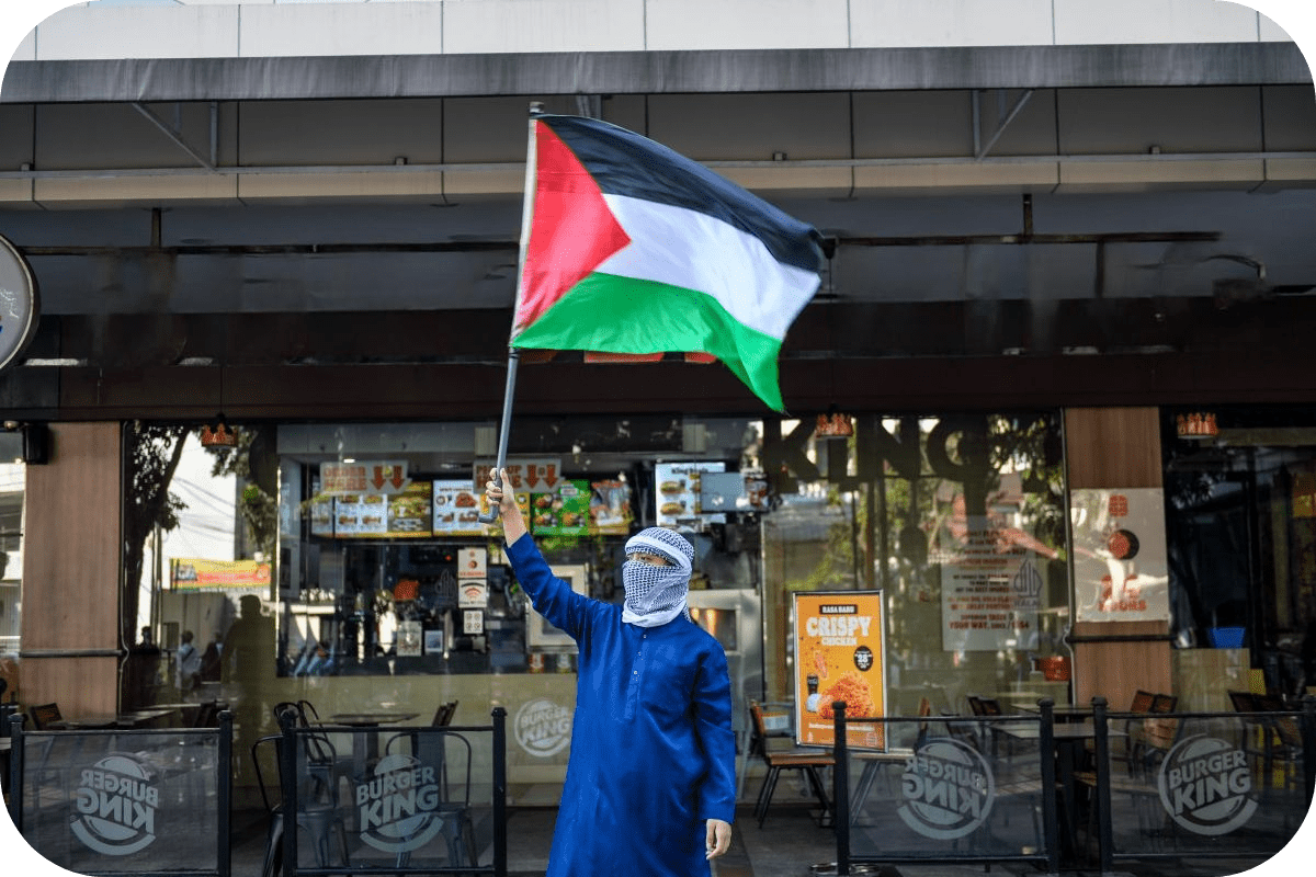 a person with Palestinian flag in front of burger king
