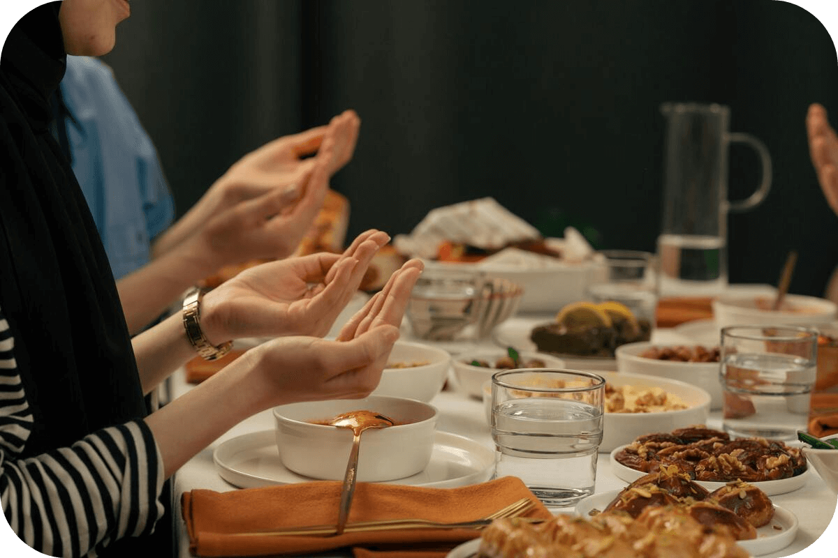 Hands raised for dua at Iftar table