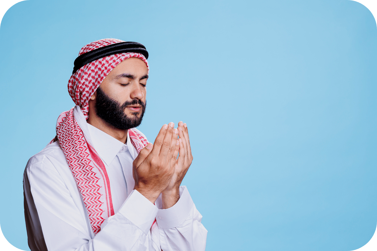 A Muslim man dressed in thobes making dua