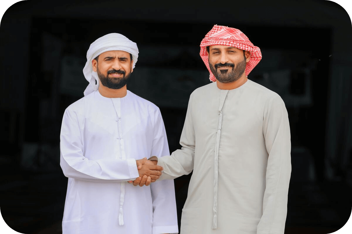 Two Muslim men in Eid thobe greeting each other