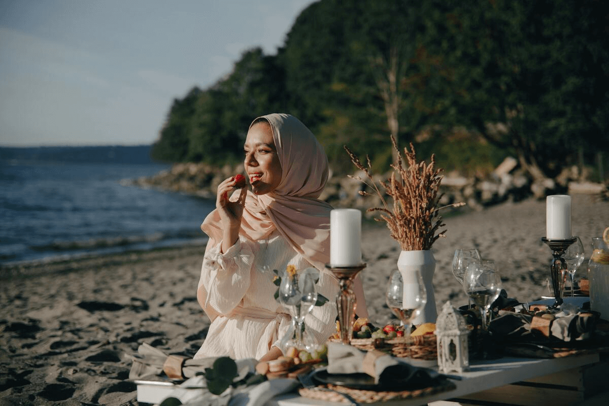 A Muslim woman wearing summer abaya and sitting on beach shore