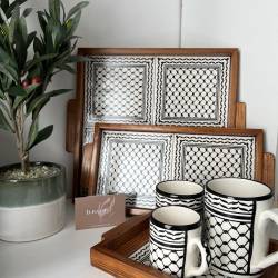 Perfect Gift Handcrafted Palestinian Olive Wood Tray with Keffiyeh Tile Design Celebrate the rich cultural heritage of Palestine with our Handcrafted Olive Wood Tray, featuring the iconic keffiyeh print tiles. Each tray is made from locally sourced olive wood, showcasing the natural beauty of Palestinian craftsmanship. The tile inlays are adorned with the kuffiyah pattern, a symbol of resilience and identity, making this tray a meaningful addition to your home. This product is sourced directly from the streets of Al-Quds, supporting local Palestinian artisans and communities. Perfect for serving tea, coffee, or as a decorative piece, these trays combine practicality with artistry.  100% handmade in Palestine  Sustainable olive wood and hand-painted ceramic tiles  Available in multiple sizes (with handles):  Large square: 36cm x 32cm Medium rectangle: 36cm x 17.5cm Small square: 17.5cm x 26cm   Ideal for home decor or serving guests  Support local trade and Palestinian craftsmanship   Please note: Each tray is handmade, so slight variations in size and finish may occur, adding to its uniqueness. Price differences from local traders are due to shipping and insurance costs.